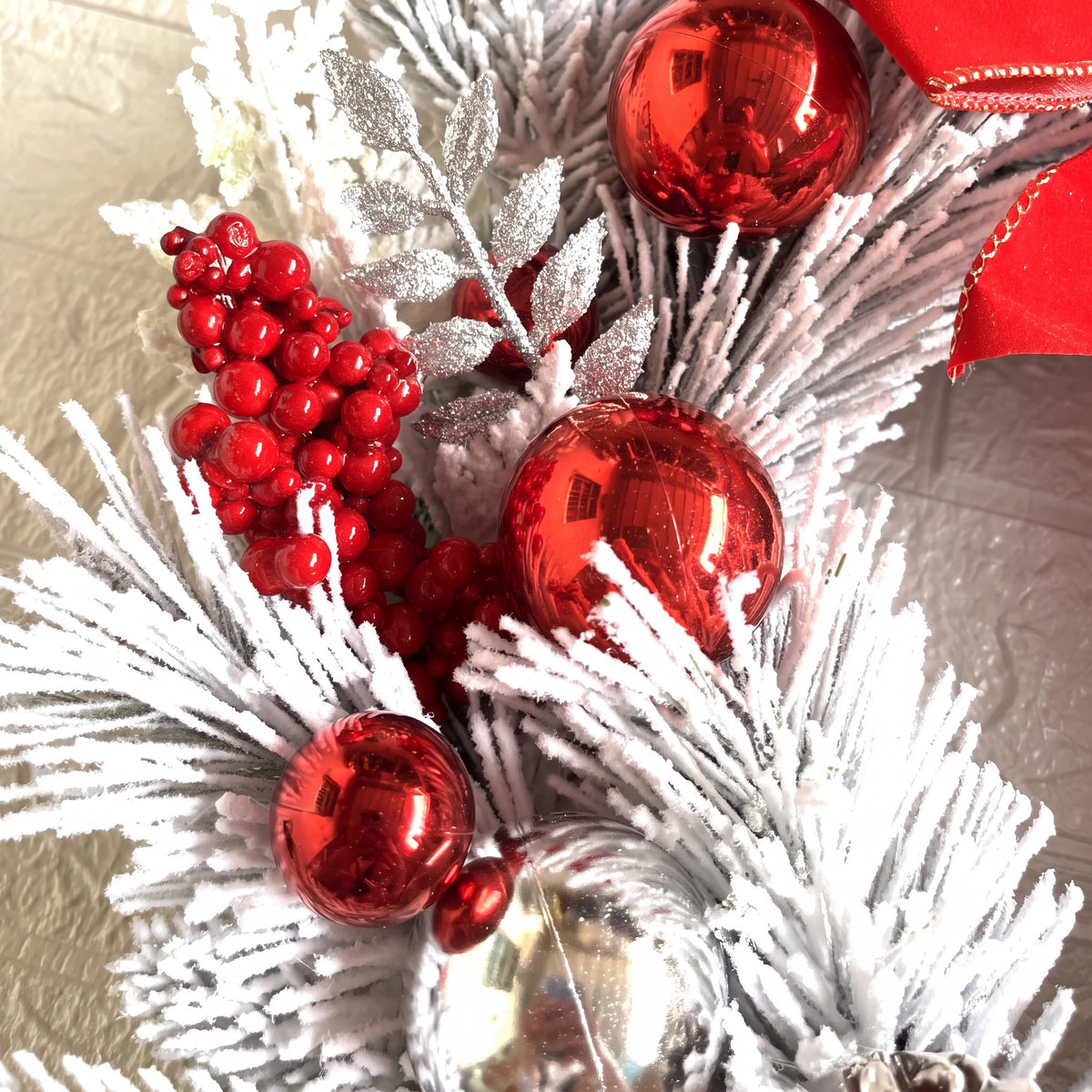 Kerstkrans met kerstballen - Besneeuwde deurdecoratie met rode strik