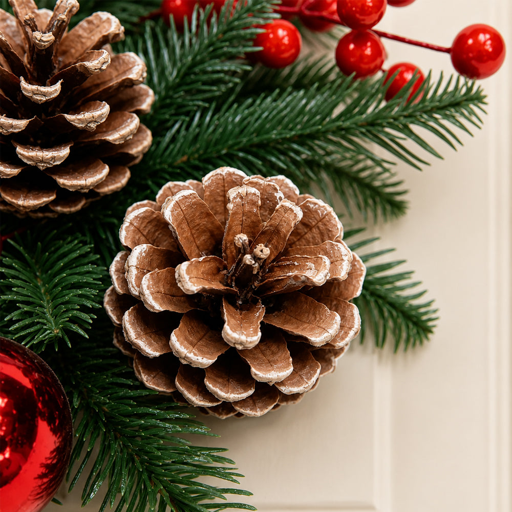 Kerstkrans met rode kerstballen, bessen en dennenappels