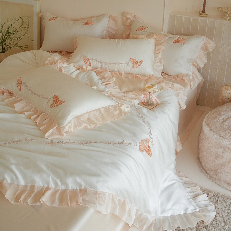 Luxe satijnen beddengoedset met chiffonachtige ruches, geborduurde vlindermotieven en elegante handgeschreven applicatie