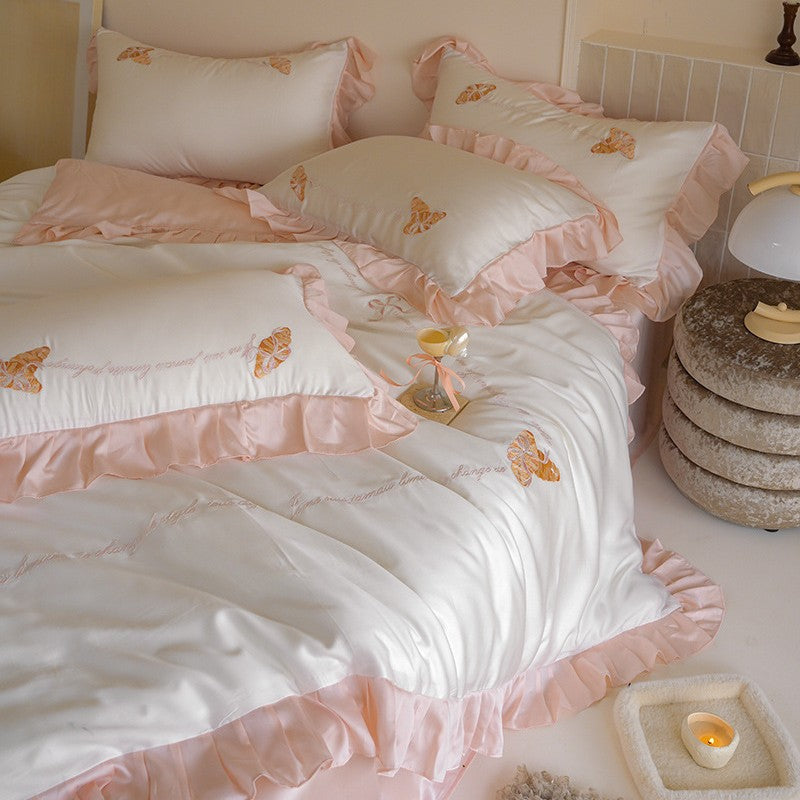 Luxe satijnen beddengoedset met chiffonachtige ruches, geborduurde vlindermotieven en elegante handgeschreven applicatie