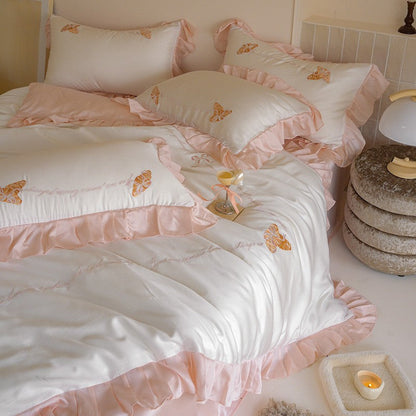 Luxe satijnen beddengoedset met chiffonachtige ruches, geborduurde vlindermotieven en elegante handgeschreven applicatie
