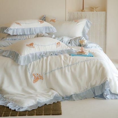 Luxe satijnen beddengoedset met chiffonachtige ruches, geborduurde vlindermotieven en elegante handgeschreven applicatie