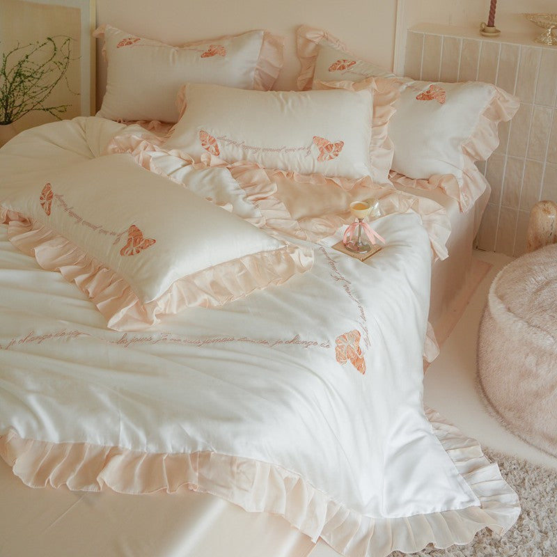Luxe satijnen beddengoedset met chiffonachtige ruches, geborduurde vlindermotieven en elegante handgeschreven applicatie