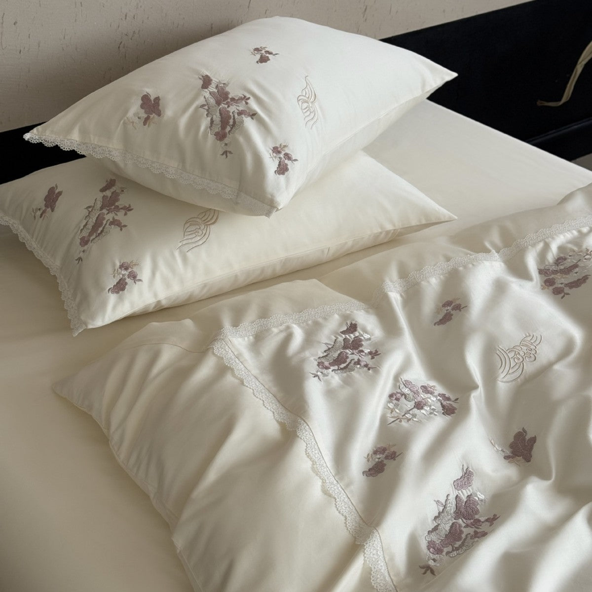 Satijnen beddengoedset met subtiel geborduurde bloemen en kanten bies